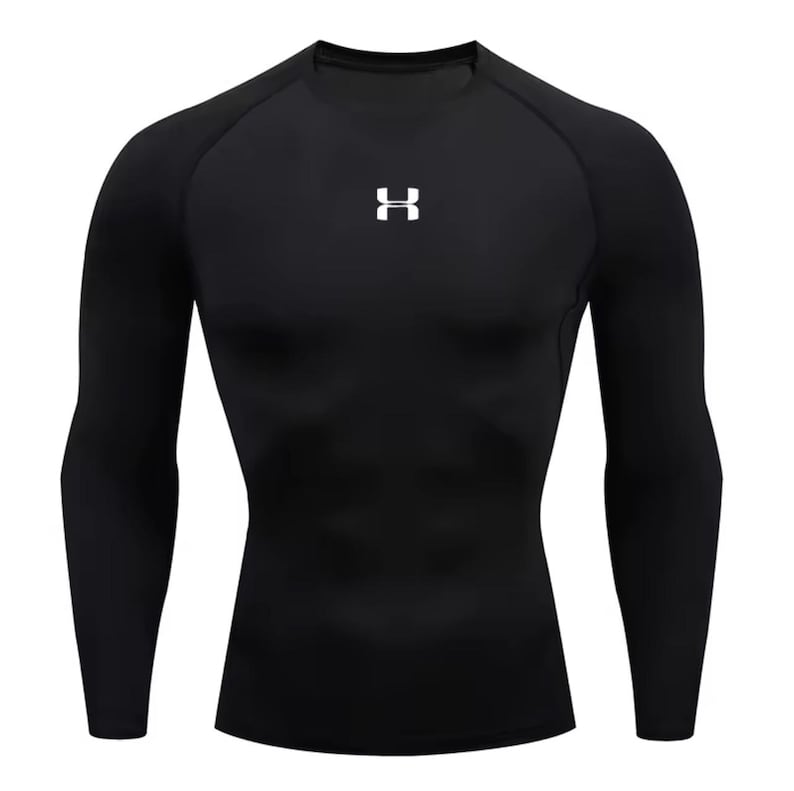 May include: Black long-sleeve compression shirt with a crew neck. The shirt features a white logo on the chest. The athletic top is designed for a snug fit and is made of a stretchy, performance fabric.