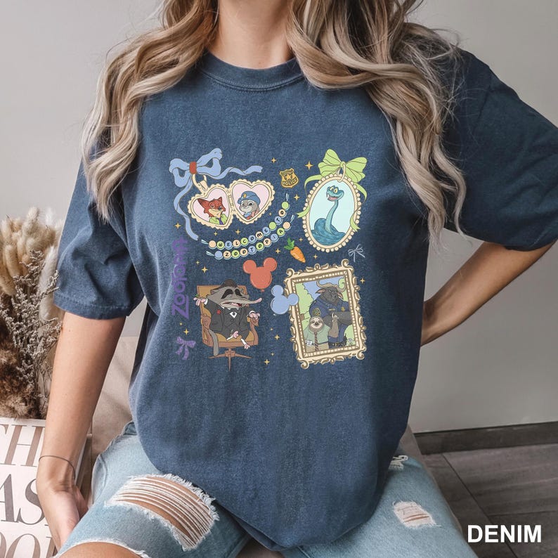 A woman wearing a blue t-shirt with various cartoon-style illustrations and text.