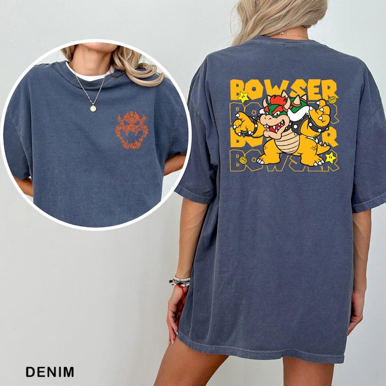 A denim t-shirt with a graphic of a character from the Mario video game franchise, specifically Bowser, printed on the back.