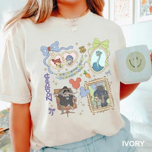 A person wearing a white t-shirt with a colorful graphic design featuring various cartoon characters and a smiley face.