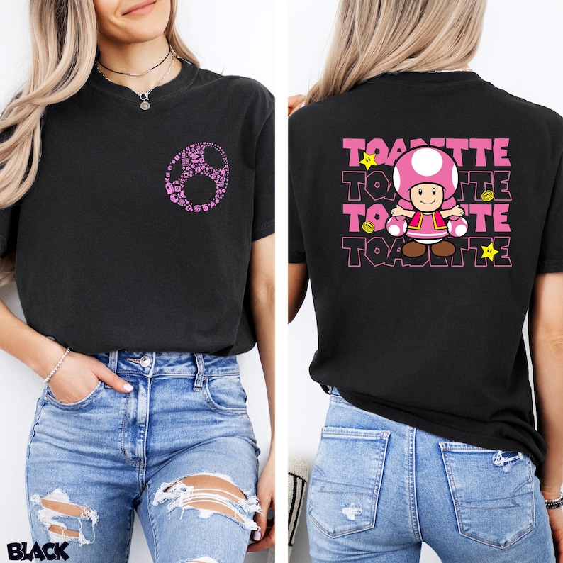 May include: A black t-shirt featuring a small pink circular graphic on the front left chest. The back displays a large graphic of the character Toadette, surrounded by yellow stars and coins, with the text Toadette repeated in pink block letters.