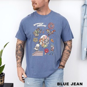 A man wearing a blue t-shirt with a cartoon character design and various other cartoon-style elements.