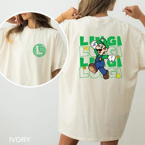A person wearing a white t-shirt with a graphic of a character from the Mario video game franchise.