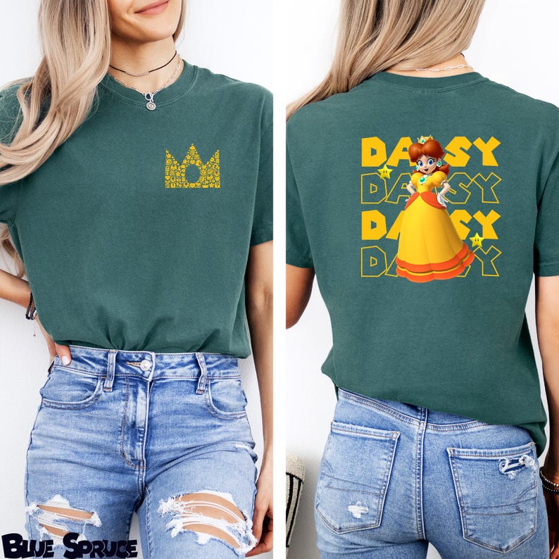 May include: A dark green t-shirt featuring a small yellow crown graphic on the front left chest. The back of the shirt displays a large graphic of Princess Daisy in a yellow dress, surrounded by the repeated text DAISY and small yellow stars.