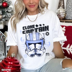 May include: A white ceramic mug with a black handle and the text "But First, Coffee" in a black, handwritten-style font. The mug is on a white surface.