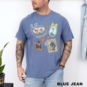 A man wearing a blue t-shirt with various cartoon characters and designs printed on it.