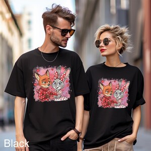 A man and a woman wearing black t-shirts with a cartoon image of a fox and a rabbit.
