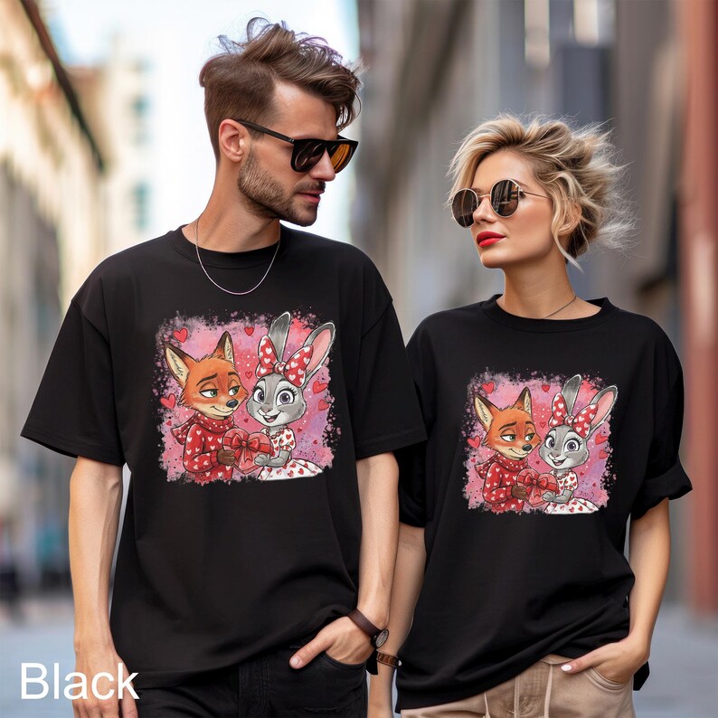 A man and a woman wearing black t-shirts with a cartoon image of a fox and a rabbit.