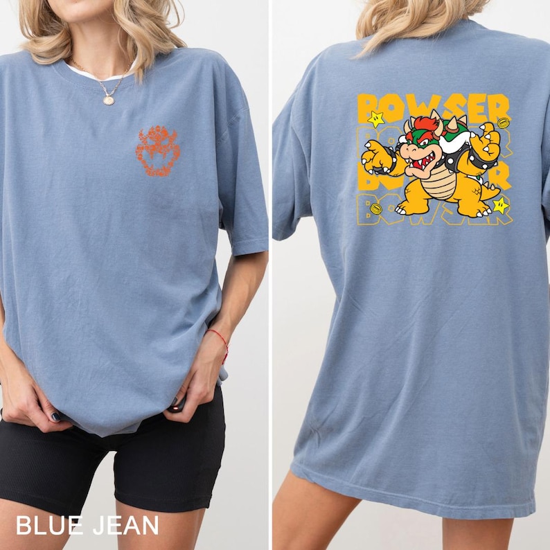 A woman wearing a blue t-shirt with a cartoon character printed on the back.