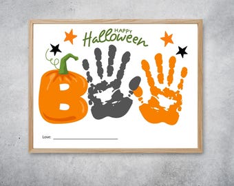 May include: A framed Halloween-themed artwork with a pumpkin-shaped "B" and handprints. The word "Happy Halloween" is written in green script above the handprints. Orange stars and a black star decorate the top.