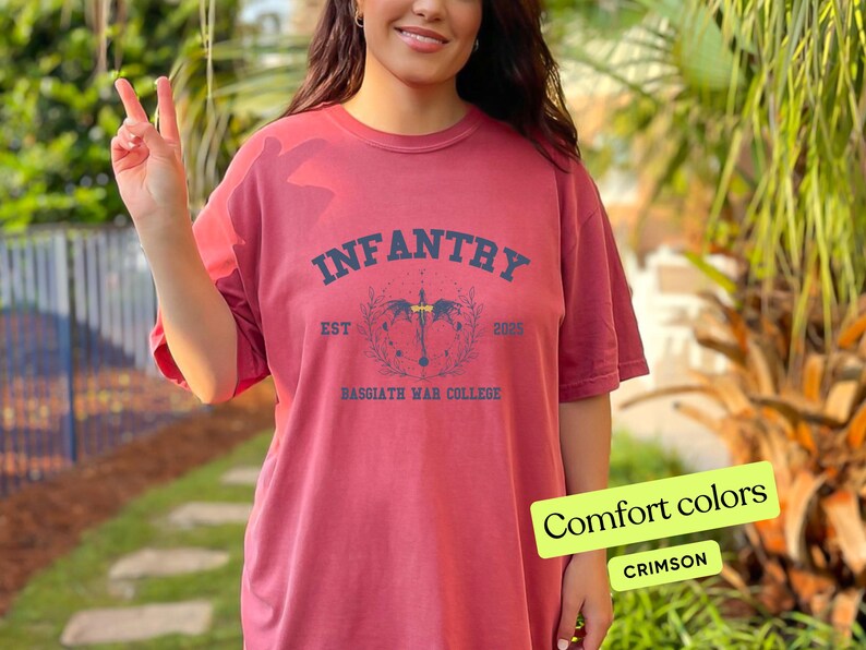 Puede incluir: Camiseta roja carmes&iacute; con un estampado gr&aacute;fico negro que dice "INFANTRY EST 2023 BASSGIATH WAR COLLEGE".