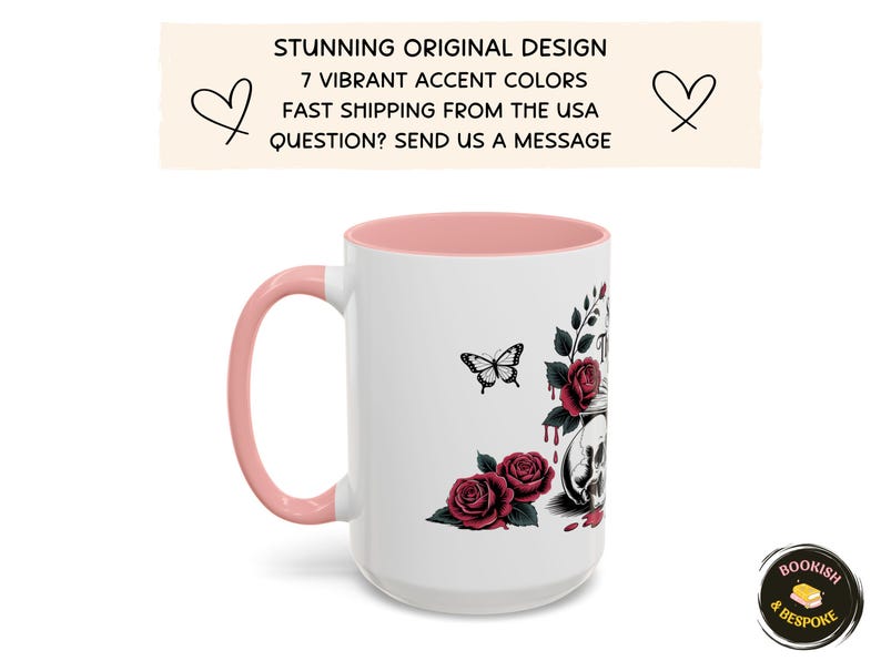 May include: White ceramic mug with a pink handle and interior. The mug features a design of a skull, roses, and a butterfly. The text on the mug reads "STUNNING ORIGINAL DESIGN" and "7 VIBRANT ACCENT COLORS".