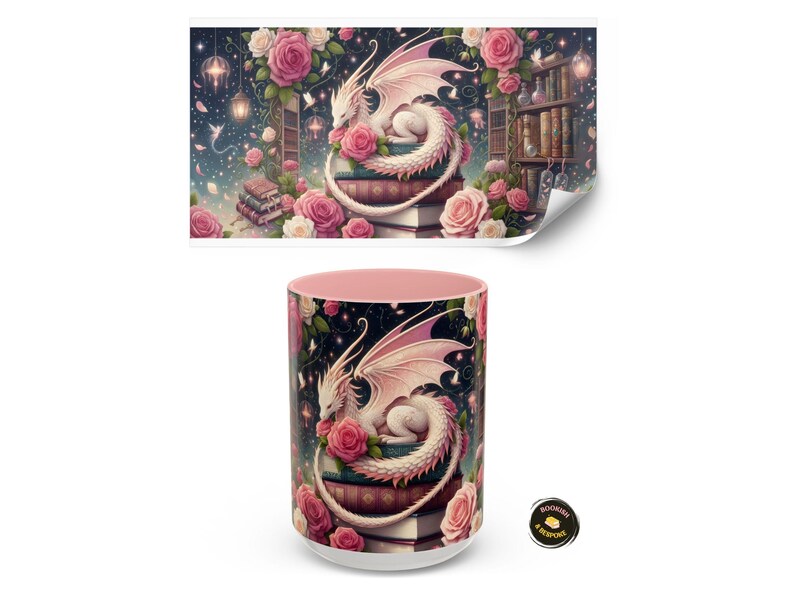 Może przedstawiać: Biały ceramiczny kubek z r&oacute;żowym wnętrzem, z fantastyczną ilustracją białego smoka spoczywającego na książkach otoczonych r&oacute;żowymi r&oacute;żami. Projekt obejmuje gwiaździste niebo i p&oacute;łkę na książki.