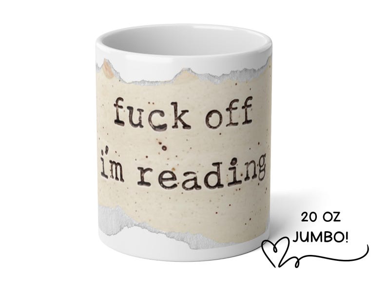 K&ouml;nnte beinhalten: Ein wei&szlig;er 20 oz Jumbo-Keramikbecher mit einer zentralen Grafik aus einem zerrissenen St&uuml;ck gealtertem, gesprenkeltem Papier. Der in schwarzer Schreibmaschinenschrift gedruckte Text lautet: fuck off i'm reading.
