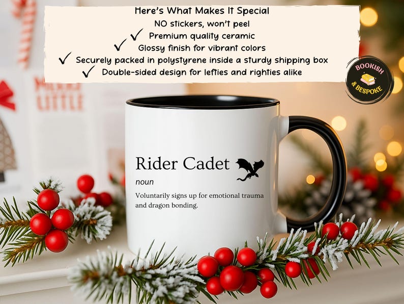 May include: White ceramic mug with a black interior and handle. The mug features the text "Rider Cadet" with a dragon graphic. The mug is decorated with holiday greenery and red berries. The mug is double-sided.