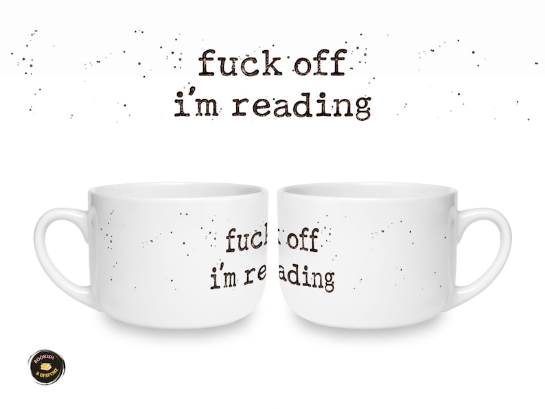 K&ouml;nnte beinhalten: Zwei wei&szlig;e Keramiktassen mit dem schwarzen, im Schreibmaschinenstil gedruckten Text "fuck off i'm reading" auf der Vorderseite. Das Design enth&auml;lt kleine schwarze Sprenkel um den Text herum, die ein abgenutztes Aussehen erzeugen.