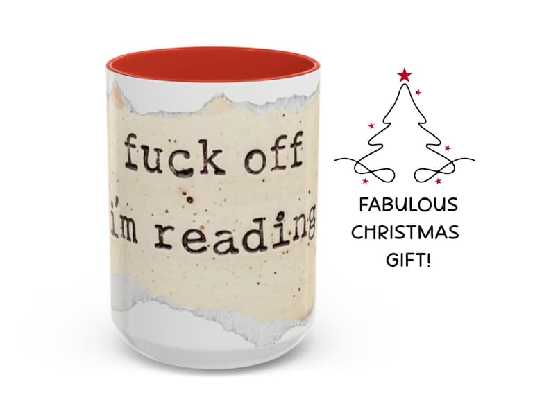 K&ouml;nnte beinhalten: Ein wei&szlig;er Keramikbecher mit rotem Innenraum, verziert mit einer Grafik aus zerrissenem Papier und dem schwarzen Schreibmaschinen-Text "fuck off i'm reading". Rechts daneben befindet sich ein schwarzes Weihnachtsbaum-Symbol &uuml;ber dem Text "FABULOUS CHRISTMAS GIFT!".