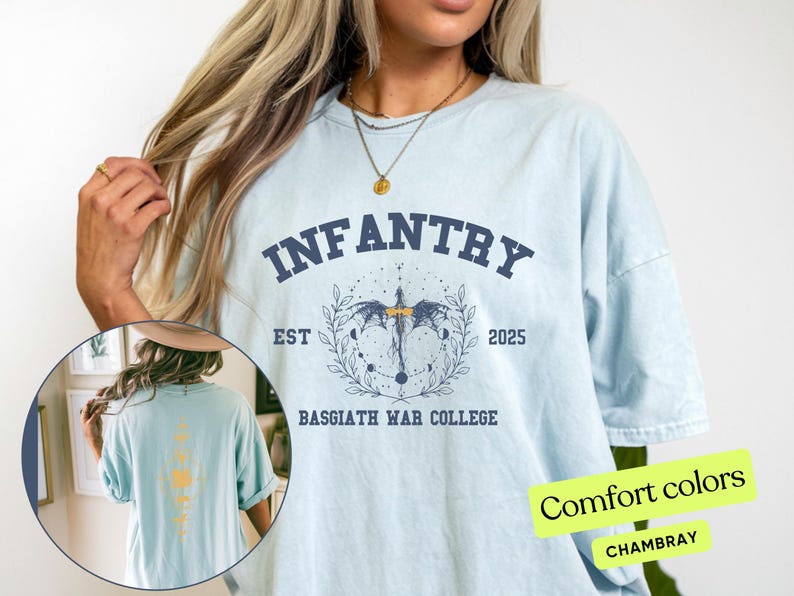 Puede incluir: Una camiseta azul claro con un estampado gr&aacute;fico de un drag&oacute;n y el texto "INFANTRY EST 2025 BASSGIATH WAR COLLEGE". La camiseta est&aacute; hecha de una tela suave y c&oacute;moda.