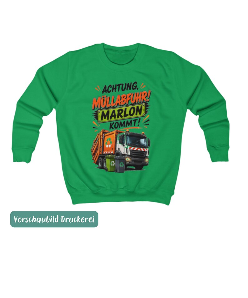 May include: A bright green long-sleeve sweatshirt featuring a graphic of an orange and white garbage truck with two trash bins. The text reads "ACHTUNG, M&Uuml;LLABFUHR! MARLON KOMMT!" in black and orange lettering above the truck illustration.