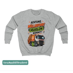 May include: A light gray crewneck sweatshirt featuring a graphic of an orange and white garbage truck with two recycling bins. The text reads ACHTUNG, M&Uuml;LLABFUHR! MARLON KOMMT! in black, orange, and green lettering on a light gray background.