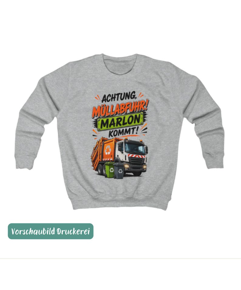 May include: A light gray crewneck sweatshirt featuring a graphic of an orange and white garbage truck with two recycling bins. The text reads ACHTUNG, M&Uuml;LLABFUHR! MARLON KOMMT! in black, orange, and green lettering on a light gray background.