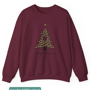 May include: A maroon long-sleeve sweatshirt featuring a central graphic of a Christmas tree with a leopard print pattern, a small brown star at the top, and a dark heart shape in the center. The text merry christmas is printed in black below.