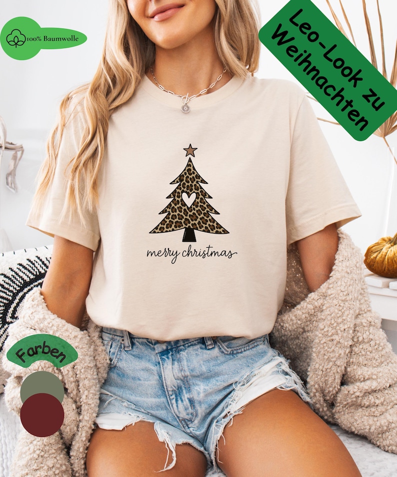 Könnte beinhalten: Beiges T-Shirt mit einem Leopardenmuster-Weihnachtsbaum-Design, einem Stern und einem Herz. Die Worte "merry christmas" sind darunter geschrieben. Das T-Shirt besteht aus 100% Baumwolle. Der Text "Leo-Look zu Weihnachten" ist ebenfalls vorhanden.