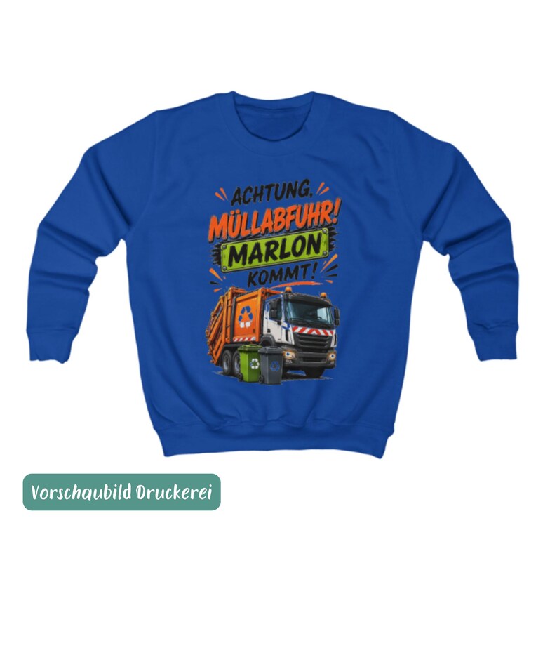 May include: A royal blue long-sleeve sweatshirt featuring a graphic of an orange garbage truck with two trash bins. The text reads ACHTUNG. M&Uuml;LLABFUHR! MARLON KOMMT! in black, orange, and green lettering above the truck illustration.