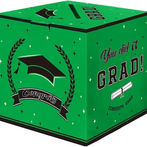 May include: A green graduation gift box with black accents and text. The box features a graduation cap, a banner that says "Congrats", and the words "You did it GRAD!" with a diploma illustration. The box is decorated with star shapes.