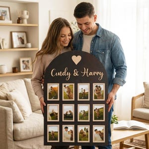 Puede incluir: Un marco de fotos de madera arqueado en color marrón oscuro con el texto "Cindy & Harry" en letras cursivas claras debajo de un icono de corazón. El marco incluye doce aberturas rectangulares para fotografías dispuestas en tres filas.