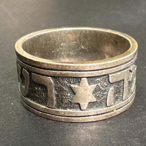 May include: A silver ring with a Star of David and Hebrew lettering around the band.