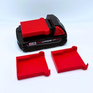May include: Black and red M18 REDLITHIUM CP2.0 battery pack with two red battery holders. The battery pack has the text "M18 REDLITHIUM CP2.0" printed on it. The battery holders are rectangular with a lip on one side.