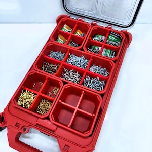 May include: A red, open, divided storage container filled with various types of screws, nails, and fasteners. The container has a clear lid and a handle. The compartments are filled with different sizes and types of metal hardware.