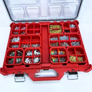 May include: A red, open, divided organizer case filled with various hardware items. The case has a clear lid and a handle. The compartments contain screws, bolts, and other small metal fasteners, ideal for organizing tools and supplies.