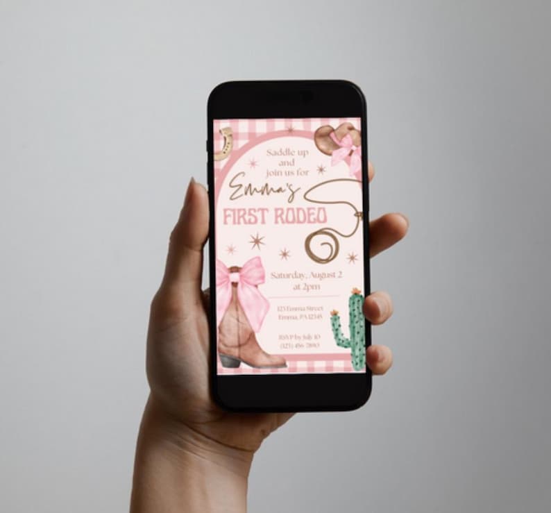 May include: A smartphone displays a rodeo-themed invitation. The design features a pink and brown color scheme with a cowboy boot, a lasso, and a cactus. The text reads "Emma's First Rodeo" with event details.