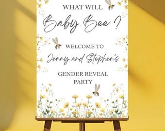 May include: A white sign on a wooden easel with the text "What Will Baby Bee?" and "Welcome to Jenny and Stephen's Gender Reveal Party". The sign is decorated with yellow flowers and bee illustrations.