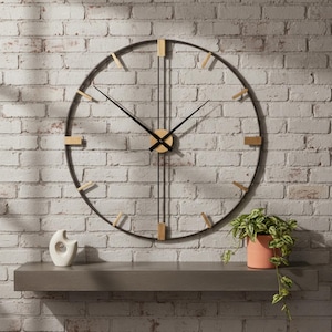 May include: A large, round wall clock with a black metal frame and wooden accents. The clock has black hands and a wooden center. The clock is mounted on a white brick wall. A shelf below holds a white sculpture and a potted plant.