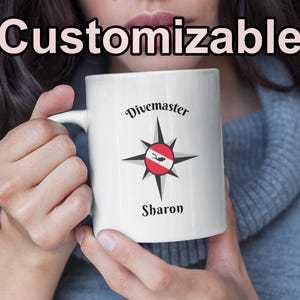 May include: A white ceramic mug with a black handle and the text "But First, Coffee" in a bold, black font. The mug is set against a neutral background, highlighting its simple design.