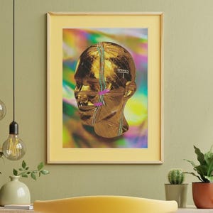 Puede incluir: Una impresión enmarcada de una cabeza dorada sobre un fondo colorido. La cabeza tiene un patrón geométrico y está parcialmente oscurecida por una línea rosa y morada.
