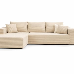 K&ouml;nnte beinhalten: Beiges Ecksofa mit Cordstruktur. Das Sofa hat eine Chaiselongue auf der linken Seite und drei quadratische R&uuml;ckenkissen. Zwei passende quadratische Kissen sind ebenfalls vorhanden. Das Sofa steht vor einem wei&szlig;en Hintergrund. Ca. 250 cm lang.