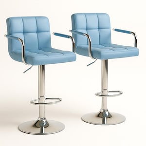May include: Two light blue, square-stitched bar stools with chrome-colored bases and armrests. The stools have a padded seat and back, and a footrest. The base is round and the height is adjustable.