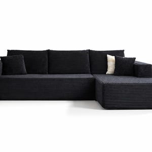 K&ouml;nnte beinhalten: Ein modernes schwarzes Ecksofa mit Cordstruktur. Das Sofa hat eine Chaiselongue auf der rechten Seite und enth&auml;lt drei gro&szlig;e R&uuml;ckenkissen und zwei kleinere quadratische Kissen. Ein cremefarbenes Kissen sorgt f&uuml;r Kontrast.