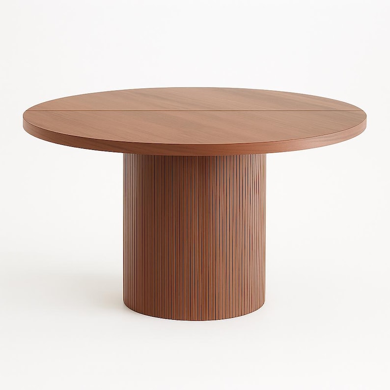 May include: A round wooden dining table with a brown finish. The tabletop is split into two sections. The base is a cylindrical shape with vertical grooves. The table is set against a white background.