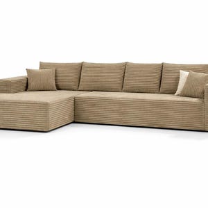 K&ouml;nnte beinhalten: Beiges Cord-Ecksofa mit einer Chaiselongue auf der linken Seite. Das Sofa hat ein niedriges Profil und enth&auml;lt mehrere passende Kissen. Der Cordstoff hat eine gerippte Textur.