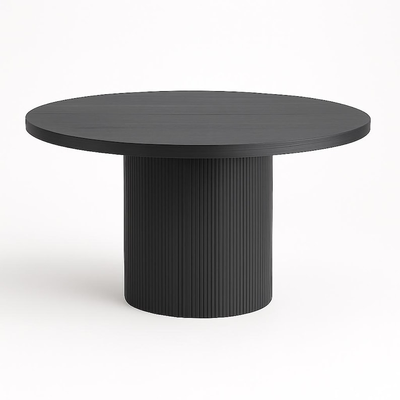 May include: A round, black dining table with a solid, cylindrical base. The tabletop is approximately 48 inches in diameter. The base features vertical, grooved detailing, adding texture to the design. The table is set against a white background.