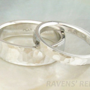 May include: Two platinum wedding bands with a hammered finish. The bands are stacked on top of each other and the inside of each band is stamped with "PLAT".