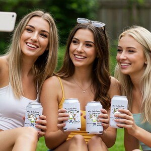May include: Three women holding white can coolers with a cartoon goose design and text. The coolers read "My Silly Goose, Betty Lane, Join The Fun, Alison's Birthday". The women are smiling and taking a selfie.