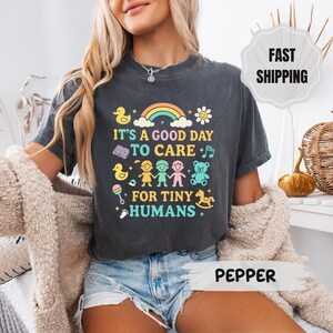 Camiseta con estampado "Cuidado con los pequeños humanos" para maestros con colores cómodos