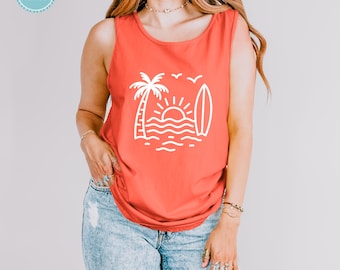 Puede incluir: Una camiseta sin mangas de color salmón brillante con un estampado gráfico blanco en la parte delantera. El diseño muestra una palmera estilizada, un sol naciente, olas del mar, una tabla de surf y dos pájaros volando en el cielo.