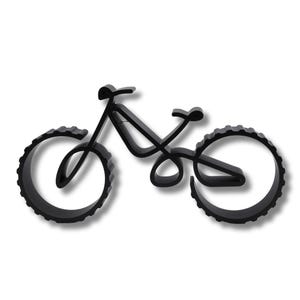 Hollow geometric bicycle sculpture with thick ridged wheels, displayed on a white background. Viewed from above at a slight angle, showcasing smooth contours and visible layering texture along the frame and wheels.